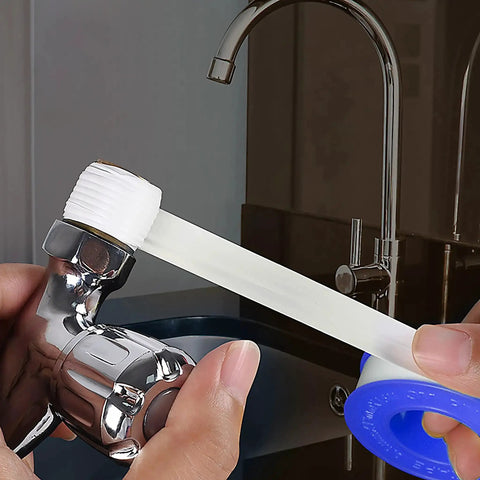 Applying PTFE Plumbers Tape Two Pack 0.5 Inch Wide Teflon Tape on pipe threads for leak sealing near a kitchen faucet.