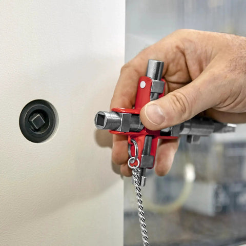 Hand holding Universal Construction Control Cabinet Key with plug in magnetic support near lock.