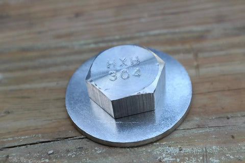 Close-up of Heavy Duty Three Eighths Inch By Sixteen Threads Per Inch Hex Bolt One Inch Long Stainless Steel 304 on wood surface