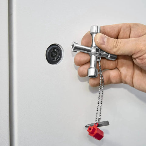 Hand using Handy Universal Control Cabinet Key for Gas, Water, and Electric Shutoff Systems with Slot 10x7 Bit near a panel lock