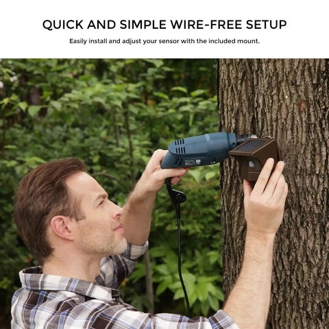 Person installing Half Mile Solar Powered Wireless Driveway Alarm With Motion Sensor on tree