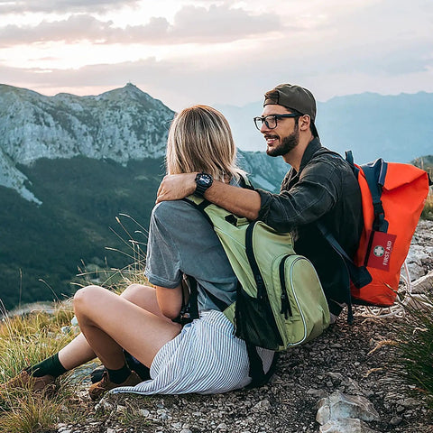 Couple hiking with backpacks, carrying a 2 In 1 First Aid Kit Set With 215 Hospital Grade Items Plus 43 Piece Mini Kit For travel and emergency use.