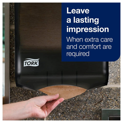 Hand using 100 Percent Recycled Multifold Towels Compatible With H2 Dispensers 16 Packs in black dispenser