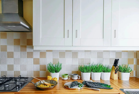 White kitchen cabinets with 30 Pack Solid 3 Inch Center To Center Slim Square Bar Drawer Handles In Brushed Nickel mounted above a wooden countertop.