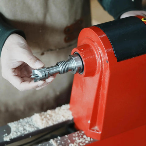 Person holding Four Prong Spring Loaded Spur Drive Center For 2MT Wood Lathe with one inch diameter and spring retracting center pin