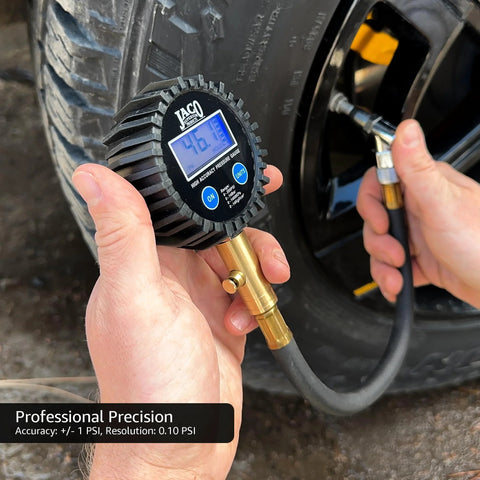 JACO ElitePro digital tire pressure gauge with brass inflator hose, rugged black body and blue LCD display on a car tire.