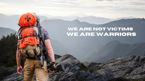 Backpacker overlooking a mountain range with text 'We Are Not Victims We Are Warriors' on an orange survival backpack.