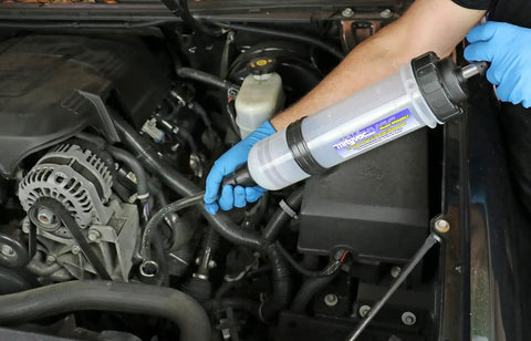 Mechanic using 1.5 Liter Fluid Evacuator And Dispensing Syringe With Twist Valve ATF Adapter in car engine bay