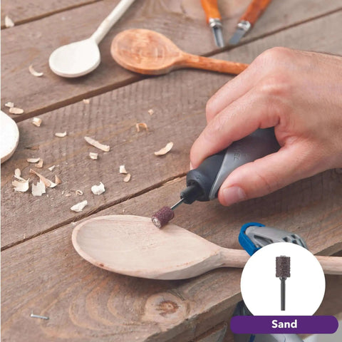 Hand using Versatile 120V Rotary Tool Kit With 15 Accessories For Wood Carving on wooden spoon, showcasing sanding tool.