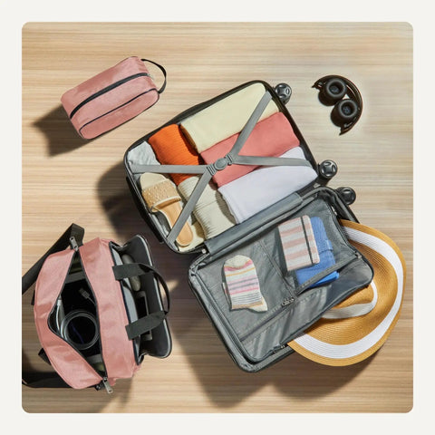 Versatile Three Piece Travel Set With 22 Inch Expandable Hardside Suitcase Eight Spinner Wheels 15 Inch Tote Bag And 10 Inch Compact Carry On Rose Gold Finish Durable Luggage Set For Weekend Getaways And Business Trips By Amazon Basics with open suitcase and packed clothes overhead view