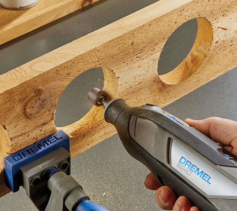 12V Cordless Rotary Tool Kit With Variable Speed And Ergonomic Comfort Grip, Includes 2Ah Battery, Charger, 5 Accessories, Wrench, And Fabric Carry Bag For Portable DIY Task Mastery By Dremel, being used to sand wood edges