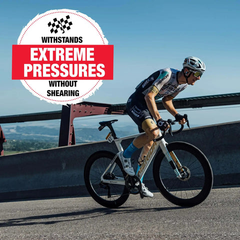 Cyclist riding on a road with a racing bicycle. A sign reads 'Extreme Pressures Without Shearing' above the image.