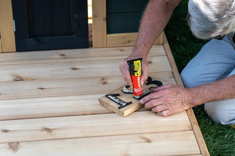 Person using Tough As Nails Durable Polyurethane Construction Adhesive For Wood Concrete Stone And Metal 4 Fl Oz Squeeze Tube on wood project