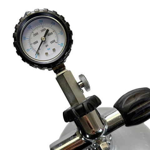 Scuba DIN tank pressure gauge with stainless steel body and black protective bezel mounted on regulator valve, 0–5000 psi