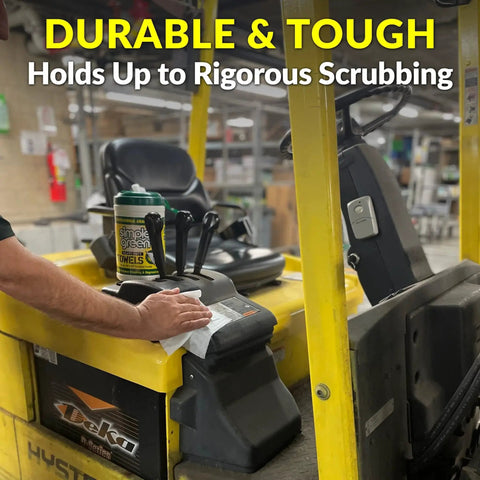 Person using Heavy-Duty Cleaning Towels and Degreasing Wipes 75 Count Pack of 2 on forklift console in a workshop setting.