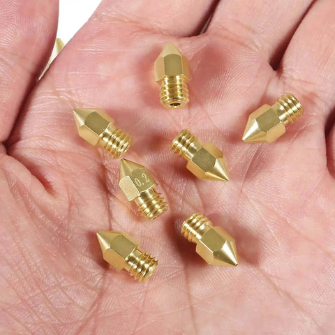 Eight 0.6mm MK8 Extruder Nozzles for 3D Printers, High Quality Replacement Nozzles, held in hand
