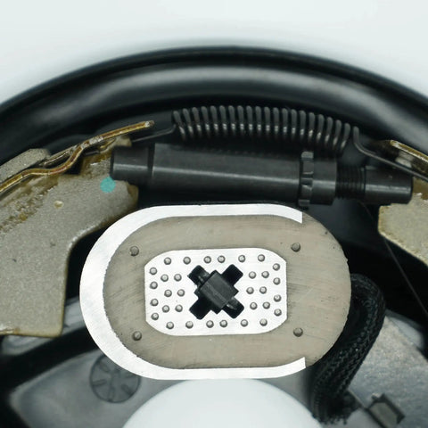 Close-up view of two 10-inch electric trailer brake magnets on backing plate for Dexter-type brakes with coil springs.