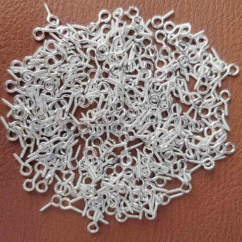 300Pcs Mini Screw Eye Pins and Hooks Set 10x5mm SelfTapping Screws in silver finish for arts and crafts on a brown surface.