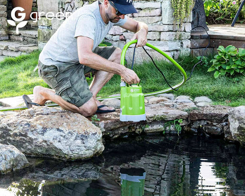 Green Expert submersible sump pump with 25 ft cord beside a garden pond.