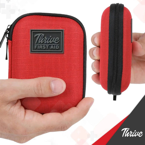Mini First Aid Kit For Travel And Adventure By Thrive, 66 Piece Red Shell Waterproof, shown in hand displaying size and texture.