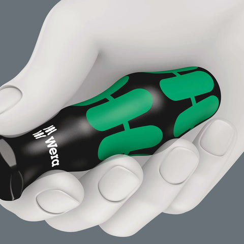 Hand holding a black and green handle of an actuation tool for terminal blocks with spring cages
