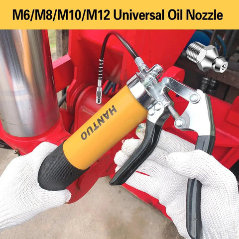 Heavy Duty Pro Grade Grease Gun With Quick Release Coupler 8000 PSI Pistol Grip Kit shown in use on red industrial machinery