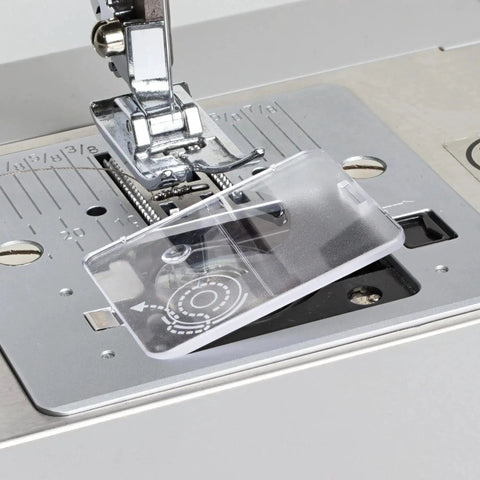 Clear plastic bobbin cover plate for Singer sewing machines; front view with presser foot and needle visible.