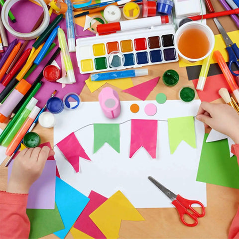 Child crafting with paper, paint, and 5 Piece Craft Hole Punch Set For Scrapbooking And Card Making, pink circle shapes visible.
