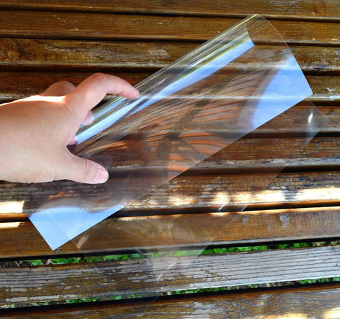 Hand holding transparent sheet, part of 10 Mil Blank 12x12 Inch Stencil Sheets For Laser Cutting Vinyl And Mylar Projects.