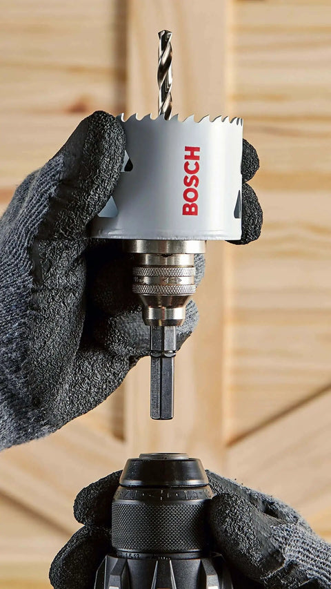 Two And A Quarter Inch Bi Metal T Slot Hole Saw With Eight Percent Cobalt M42 Alloy For Pro Grade High Temperature Tougher And Cleaner Cuts In Metal Wood And Plastic Featuring Triangle Chip Clearance For Quick Plug Removal Bosch HBT225 held by gloved hands
