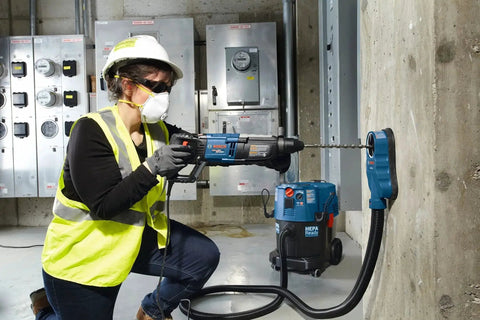 Person using a Bosch rotary hammer with Two Cutter Head SDS-Plus Rotary Hammer Bit For Concrete Drilling, One Half Inch By Six Inch By Eight Inch.