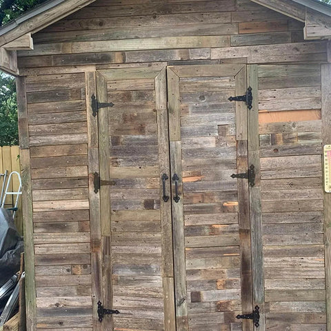 Wooden shed with Six Pack 5 Inch T Shape Strap Hinges With Screws, classic black decorative gate hinges installed on doors.