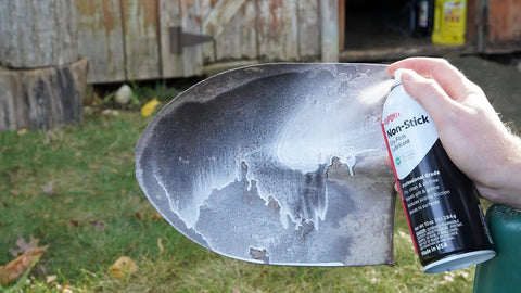 Applying Nonstick Dry Film Lubricant Aerosol 14 Oz Ultra Thin Dirt Resistant Coating to a metal shovel blade for protection