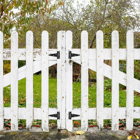 White wooden fence with Ten Pack 4 Inch T Strap Tee Hinge Heavy Duty Black Barn Door Hinges for garden doors, outdoor installation view.