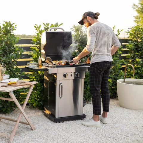 Man grilling on outdoor gas barbecue with lid open in garden setting