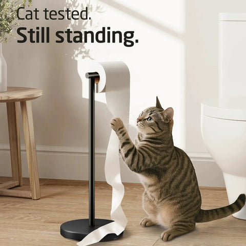 Cat interacting with freestanding matte black toilet paper holder stand, rustproof SUS304 stainless steel with heavy 3 lb base for stability.