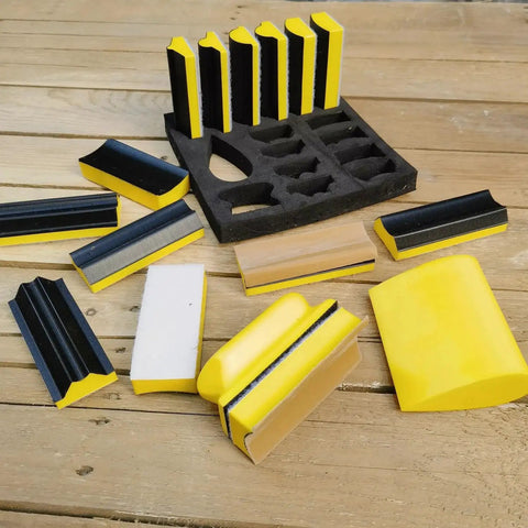 16 Piece Contoured Sanding Block Set With Interchangeable Convex Concave Shapes on a wooden surface