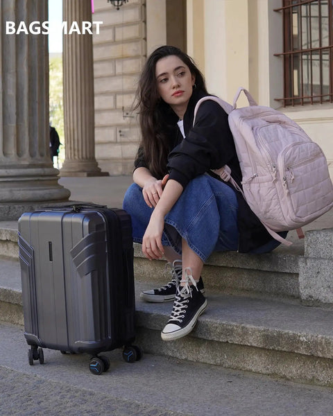 Woman sitting with Expandable Carry On Luggage Airline Approved 22x14x9 Inches 35 Liter Capacity Ultra Lightweight 6.83 Lb 100 Percent Polycarbonate Hard Shell 20 Inch Spinner Wheels Waterproof Rolling Suitcase Gray