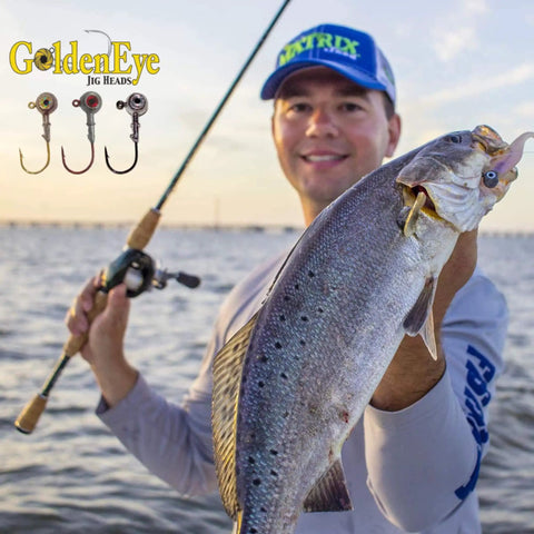 Angler holding fish caught with Inshore Jig Head For Soft Plastics With Red Eye And Red Hook 1/4 Ounce 5 Count Pack