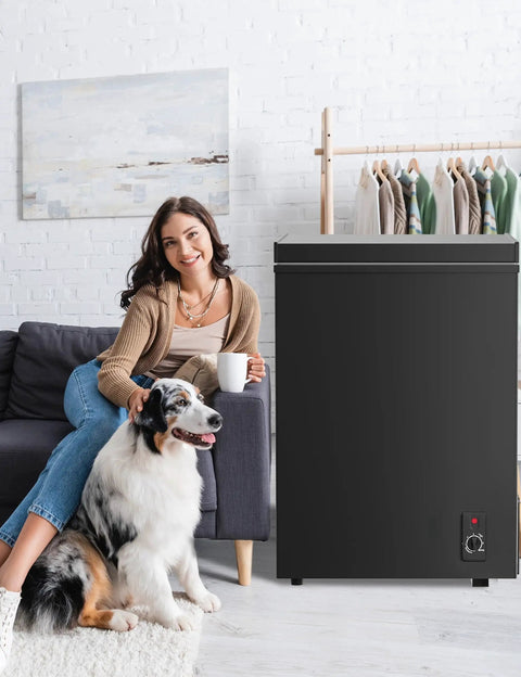 Ultra Quiet 5.0 Cu Ft Deep Freezer With Compact Design For Home And Small Shops next to woman on sofa with dog in living room.
