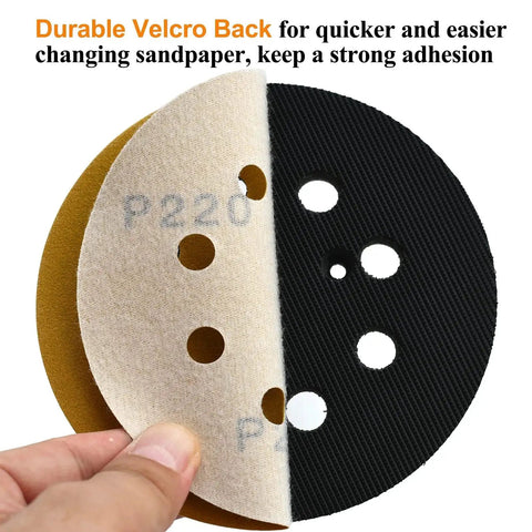 Close-up of 5-Inch 220 Grit Hook and Loop Sanding Discs showing Velcro backing and 8-hole design, held by hand.