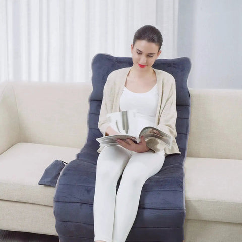 Woman sitting on Full Body Massage Mat With Heat And 10 Vibrating Motors Memory Foam Pad, reading on couch, home spa vibe