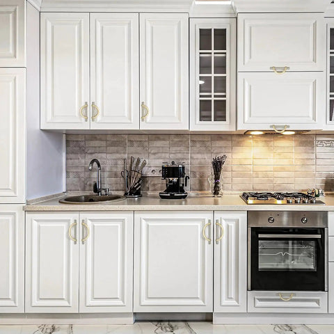 Brushed Brass And Brushed Nickel Cabinet Pulls 5 Inch Center To Center Curved Handles installed on white kitchen cupboards.