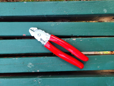 Heavy Duty Hog Ring Pliers With 3/8 Stainless Hog Rings Spring Loaded Jaws PVC Grips 7 Inch on green surface