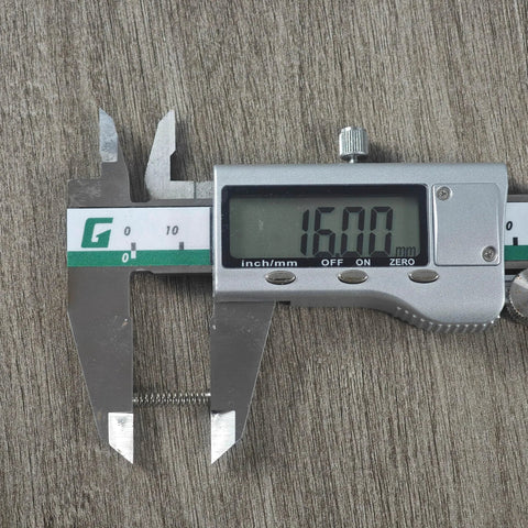 Stainless steel Cherry MX switch spring measured at 16.00 mm with a digital caliper.