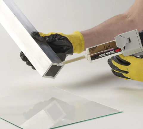 Applying 3M Scotch-Weld Clear Epoxy Adhesive DP100 Plus with High Sheer and Peel Strength to metal surface, using dispensing tool, close-up view.