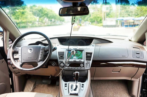 Wingbrake-V driver training brake hanging from rearview mirror inside a sedan; black cord with silver knob.