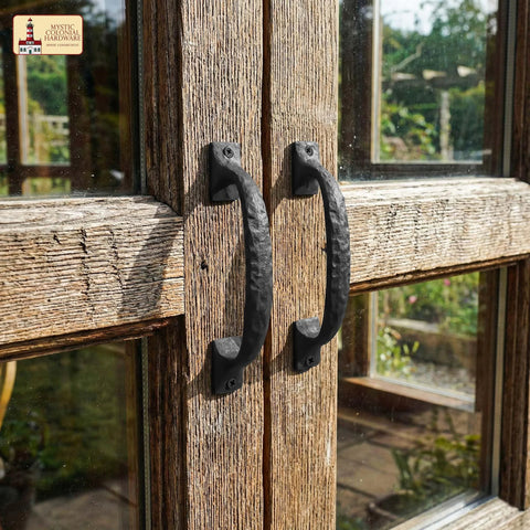 Twisted Grip Mystic Colonial Rustic 6.5 Inch Barn Door Handle Pull for Sliding Barn Doors in black wrought iron on a wooden gate.