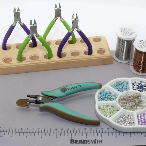 Metal Hole Punch Pliers With Gauge Guard for 22 gauge metal, displayed with bead tools and materials for jewelry making