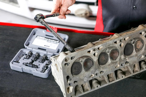 7 Piece Master Thread Chaser Set for Automotive Repairs with Storage Case shown on workbench next to engine component.